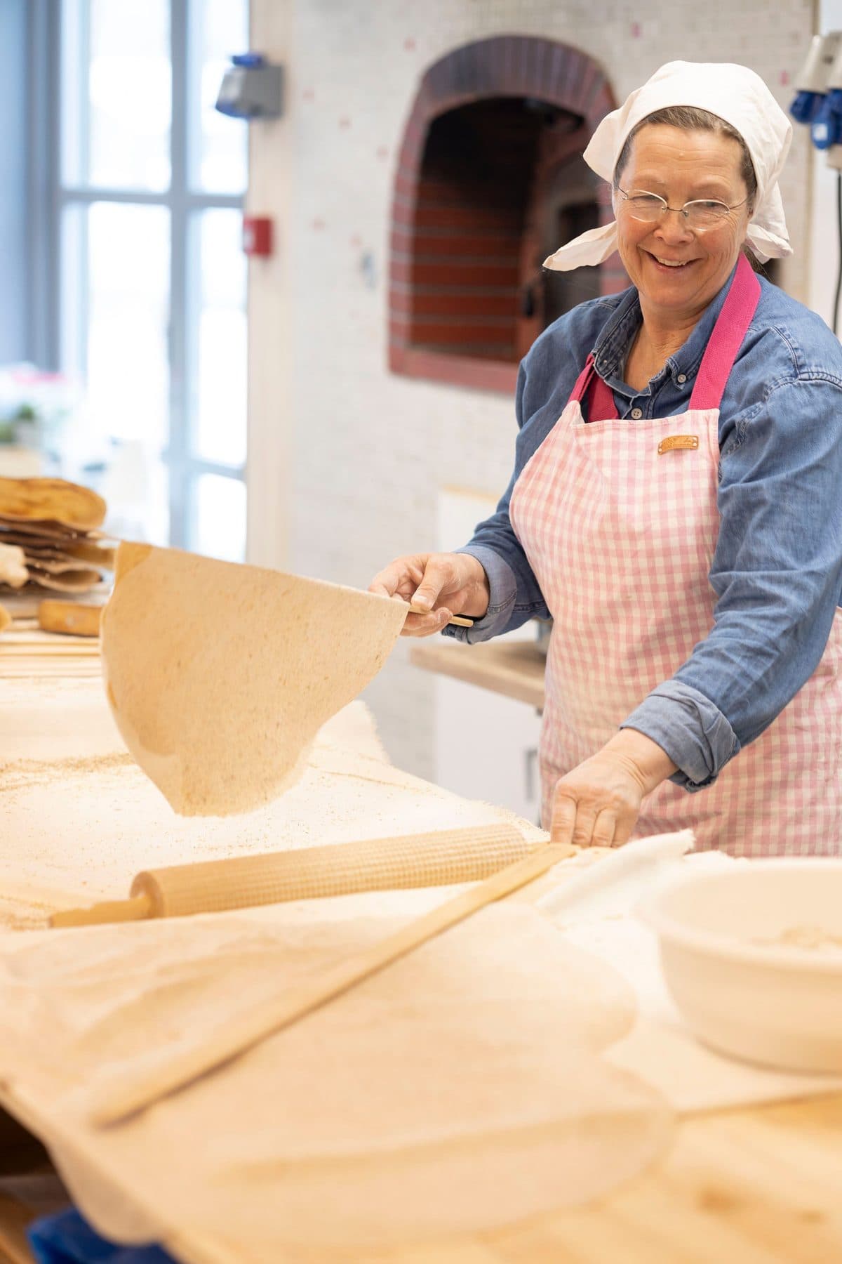 Gro løftar eit flatbrød av takka i bakeriet
